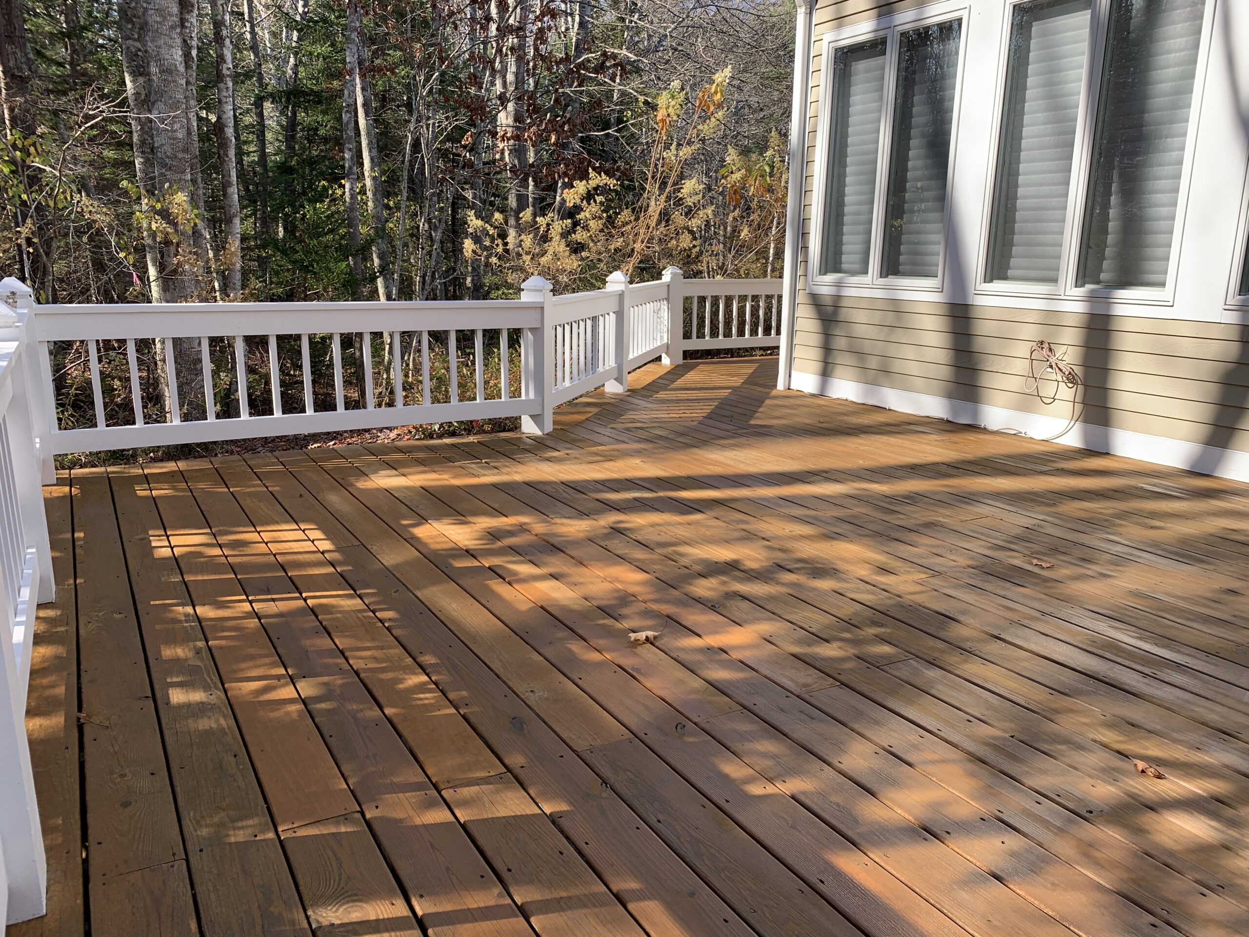 Pressure treated decking with a semi-solid stain in the New England fall season