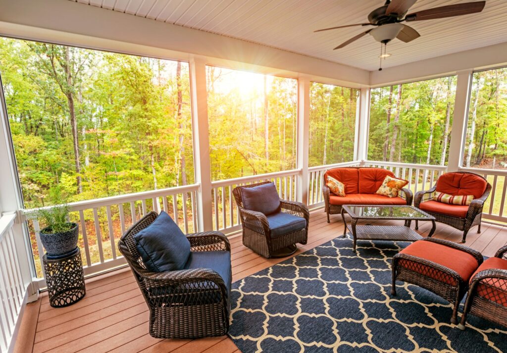 A sunny screen porch with brightly colored plush furniture